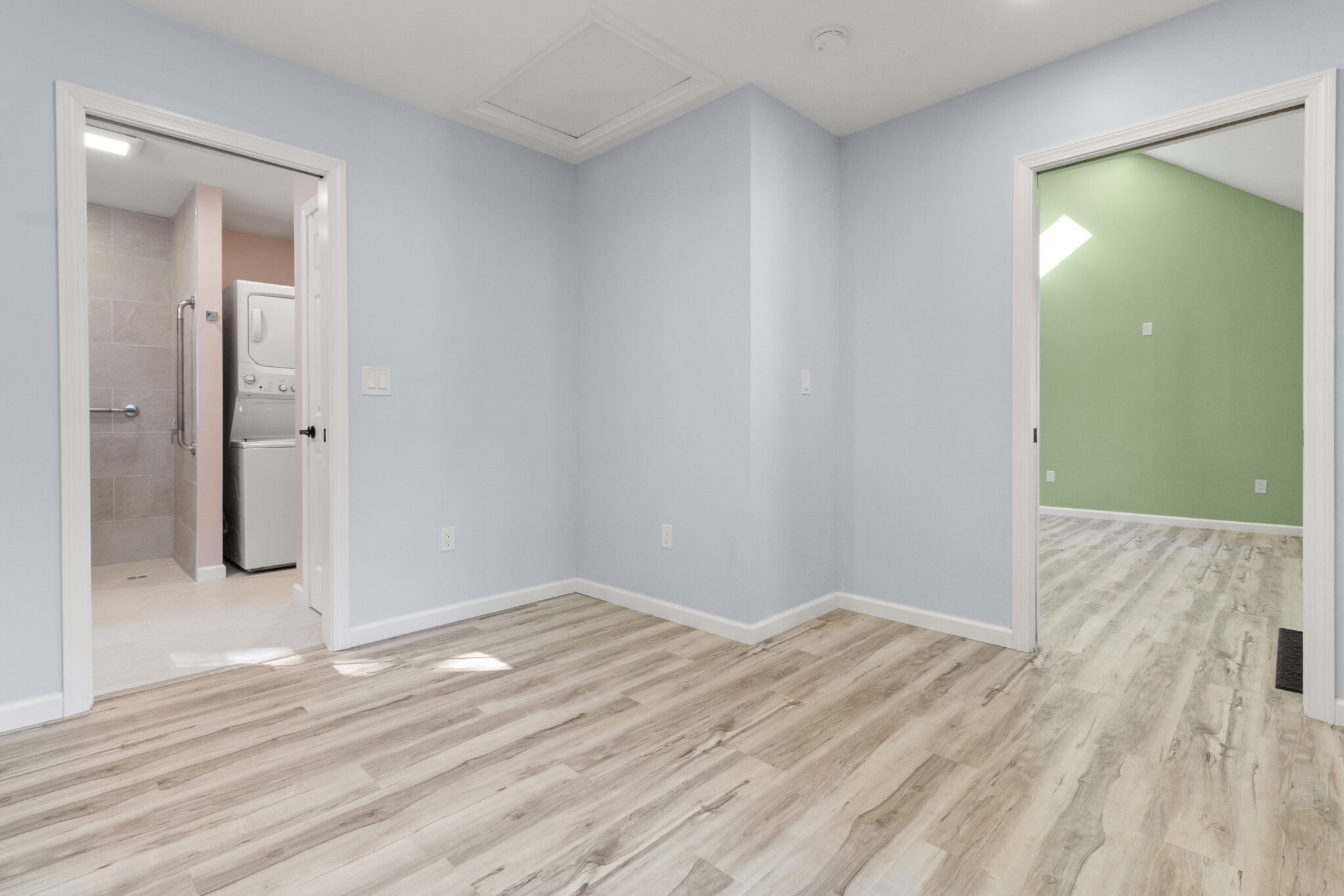 Finished room with light blue-gray walls, wood-look flooring and white trim in Groton, CT