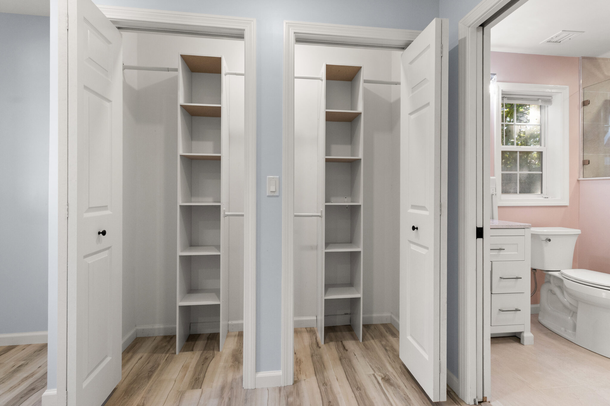 Finished interior with white built-in shelving, storage cabinets and doorway in Groton, CT