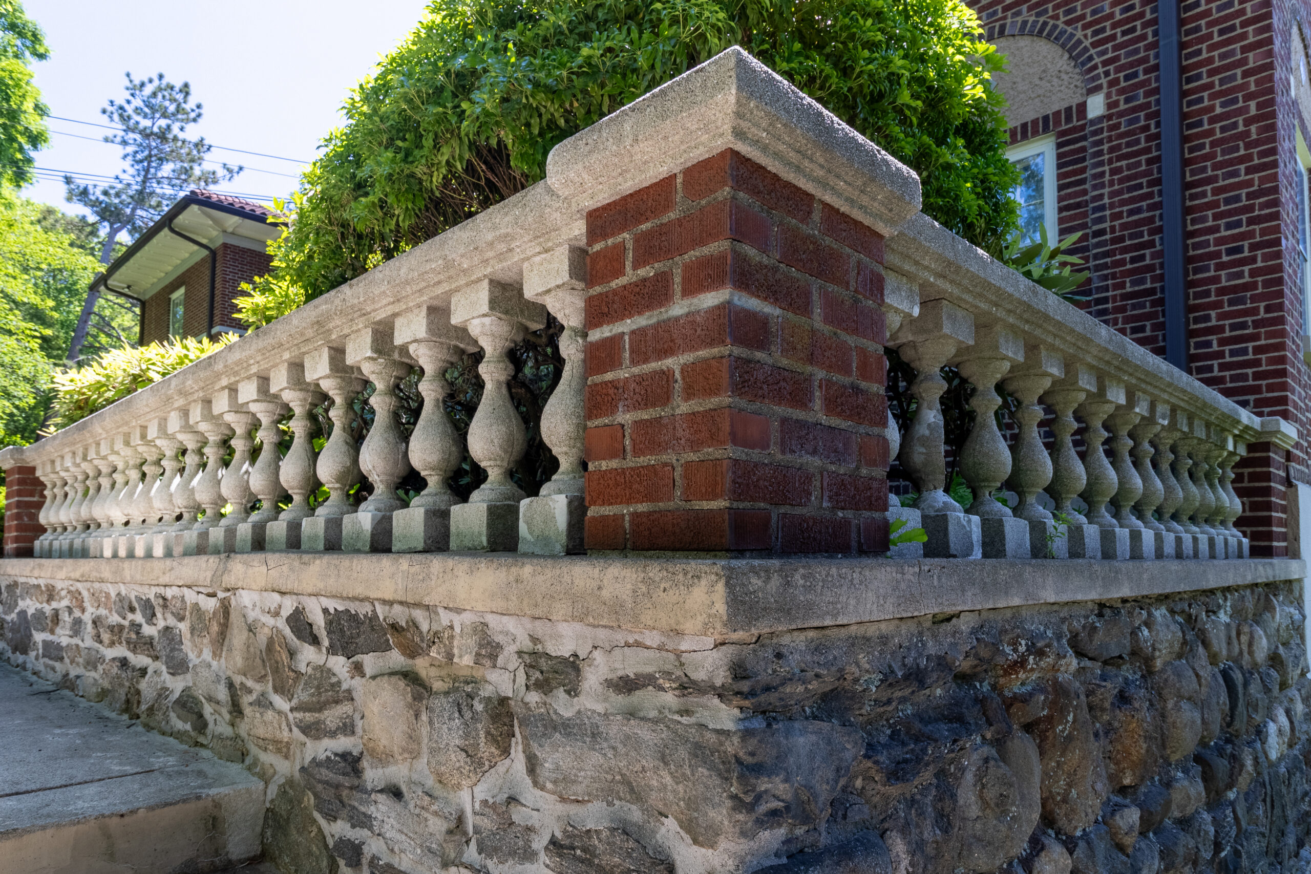 Brick and stone balustrade with decorative columns along an outdoor terrace